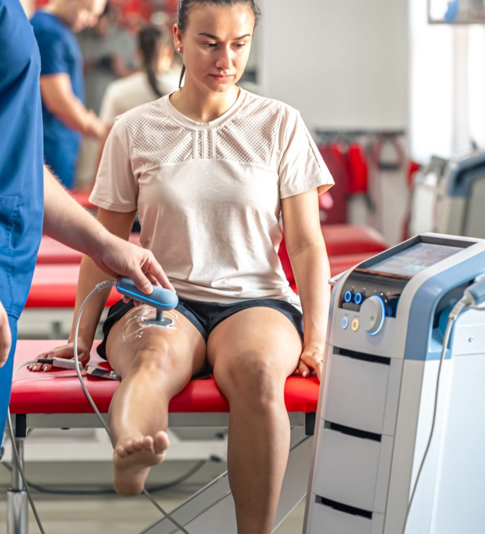 Doctor using machine to treat the knee joints of a patient, T-CaRe technology, resistive and Capacitive therapy.